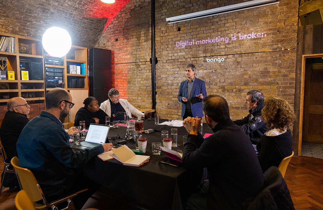 Man presenting to a group of people at a table